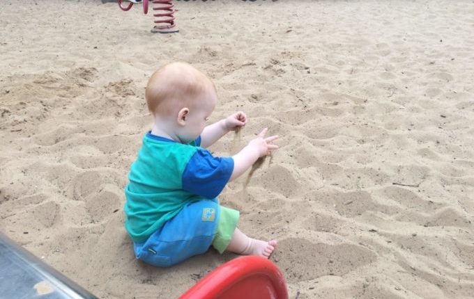 Spielplatz - Kind spielt mit Sand