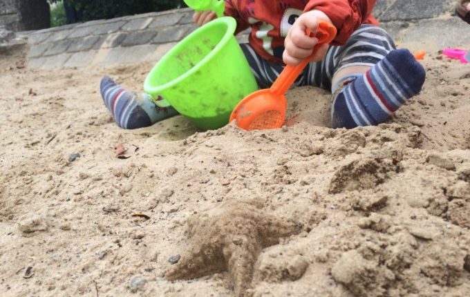 Spielplatz in der Louis-Lewin-Straße - Kind spielt im Sand mit Buddelzeug