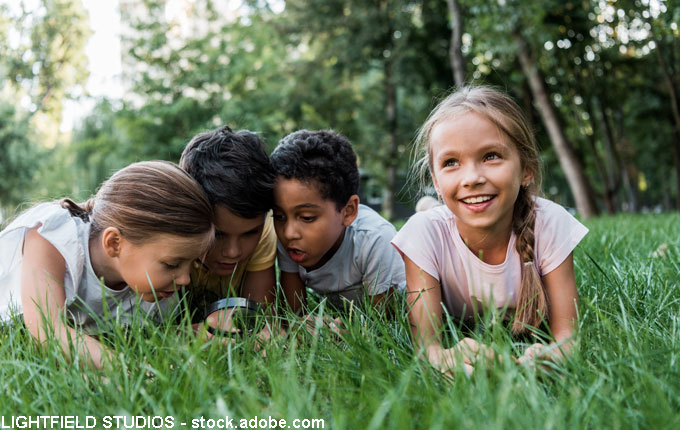 Kind mit Freunden auf der Wiese